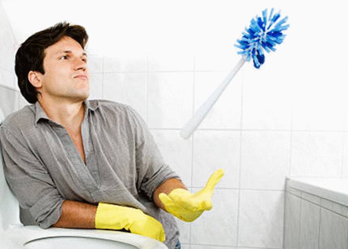 homme-avec-gants-ménage-regardant-la-brosse-WC-en-la-faisant-sauter-dans-la-main