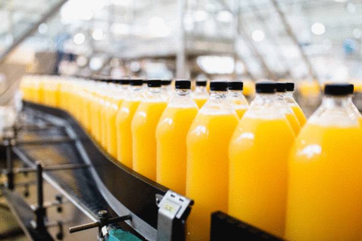 ligne-de-bouteilles-de-jus-d-orange-dans-une-usine