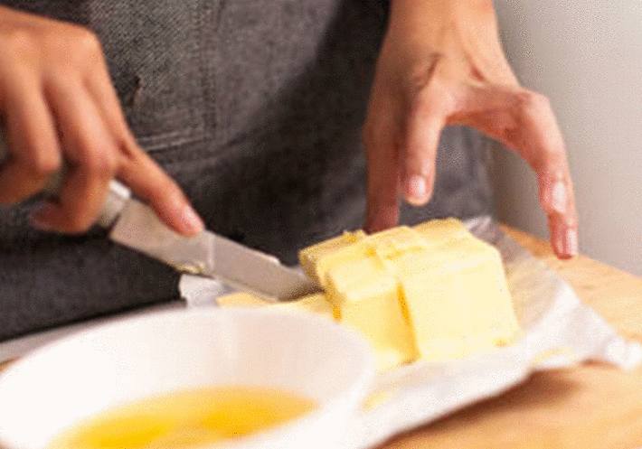 main-découpant-du-beurre-en-cube-avec-un-couteau