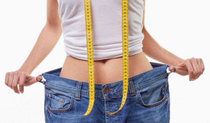 une jeune femme flotte dans son jean après avoir suivi le régime basse calorie